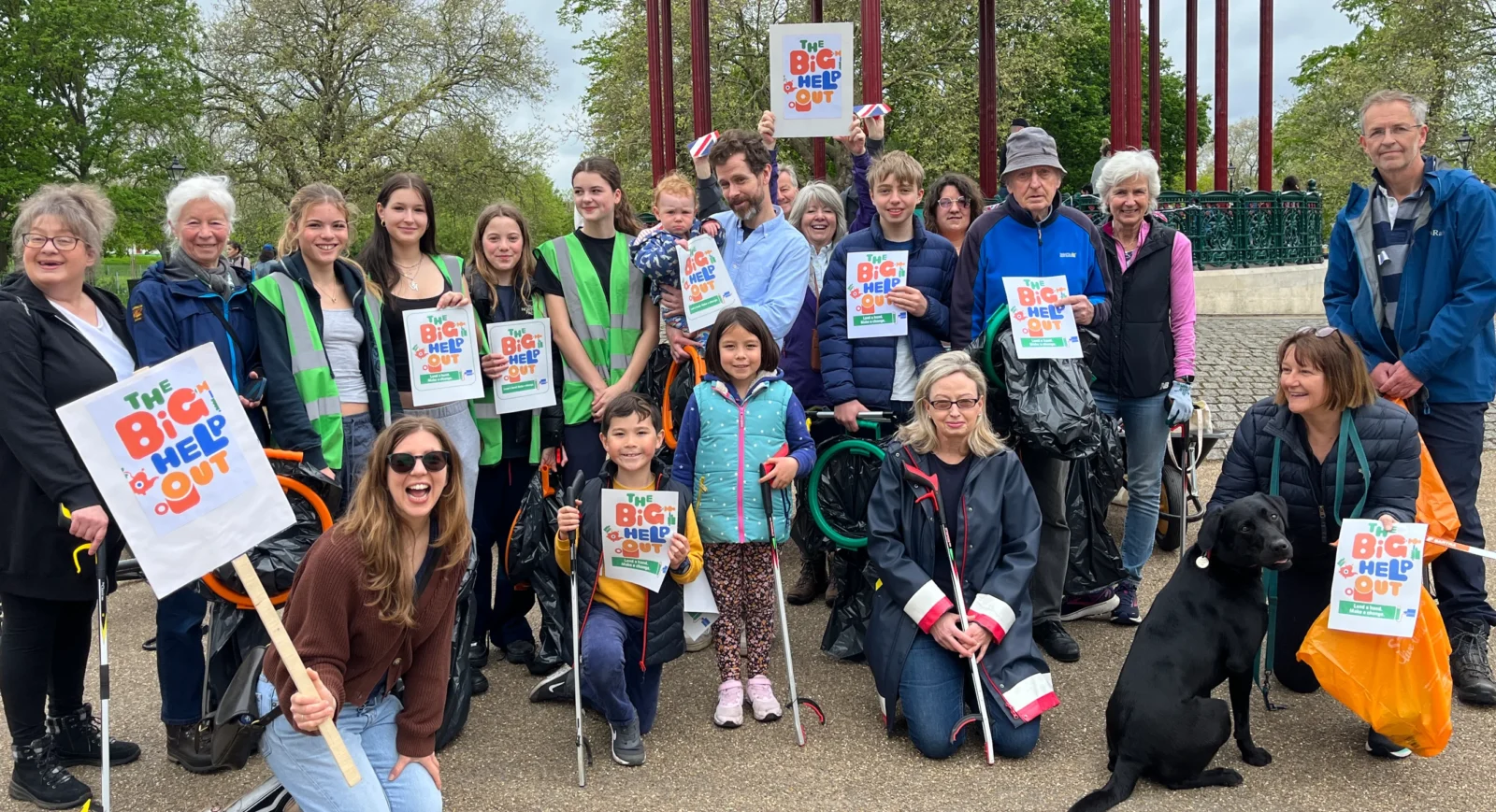 A group of people of all ages, holding Big Help Out signs