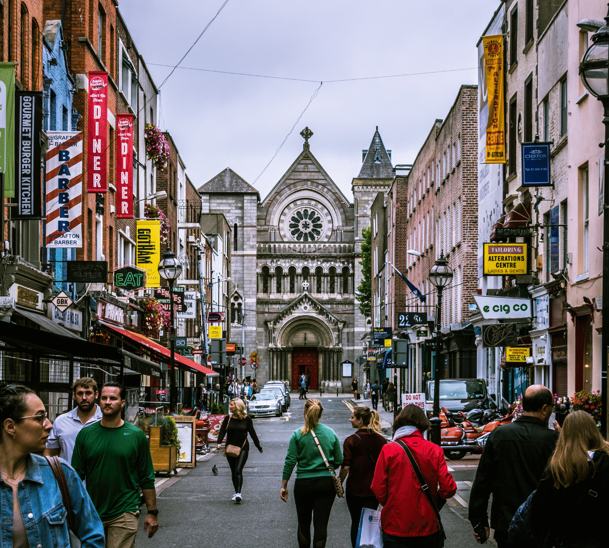 People walking on a UK high street with shops on the left and right hand sides